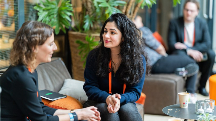 Image of the ONE conference event, two women talking with each other.
