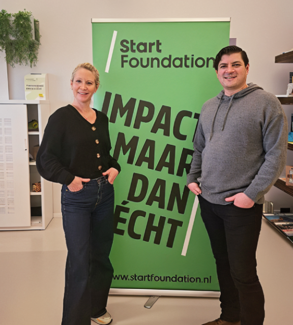 Owner Khaled in front of a green banner saying "Impact maar dan echt"