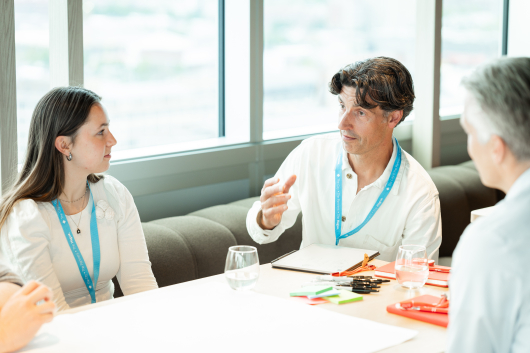 A man and woman conversing during a meeting.