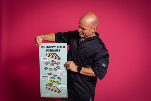Man holding a poster of the happy toast formula.