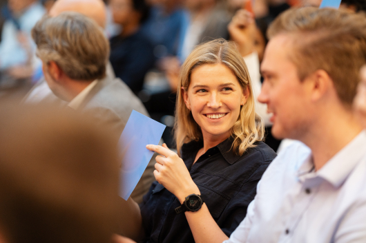 A blonde girl smiling in the crowd