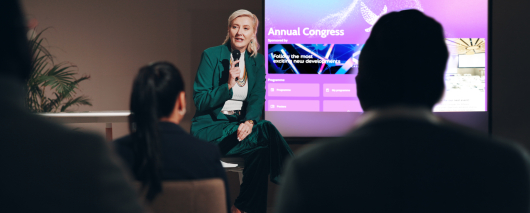A female speaker presents during a conference.