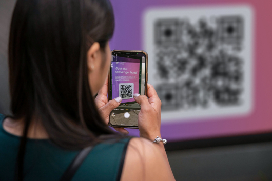 A woman scans a QR code for an event.