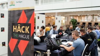 Image participants sitting behind laptop at the event Hack The Hague