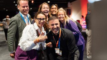 Image of participants smiling at camera at ONE conference business event