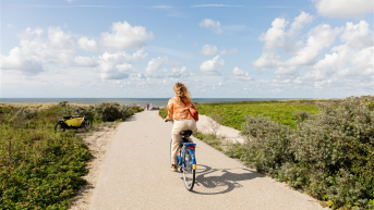 Girl cycling through the dunes of The Hague