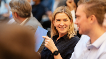 A blonde girl smiling in the crowd