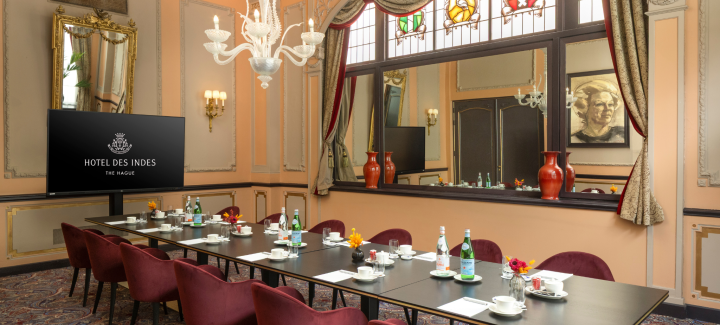 Elegantly decorated meeting room with a long table, chairs, and decorative lighting.