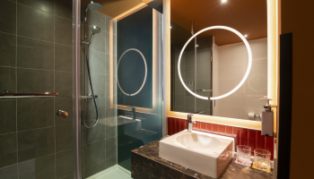 A modern bathroom featuring a shower and sink.