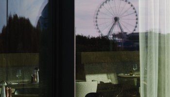 Reflection of a restaurant with a view of a Ferris wheel.