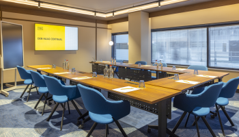 Modern meeting room with blue furniture and a screen.