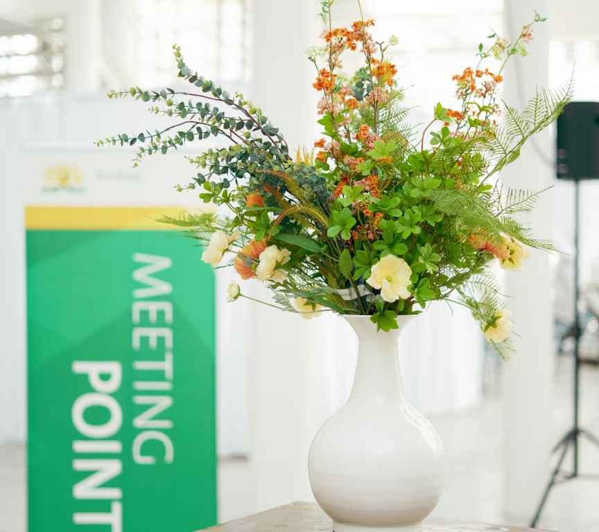 White vase with flowers and a green banner