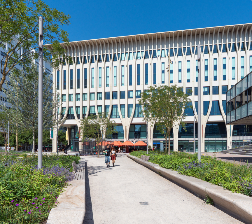 Modern architecture with trees and people on the path.