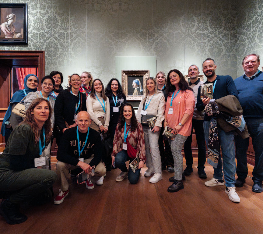 A group of 15 people posing in a museum.