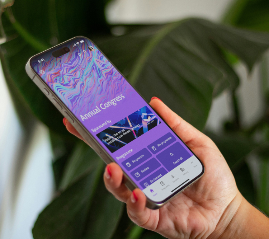 A hand holding a smartphone displaying a congress app.