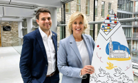 Image of international sales advisors Joris and Eline holding branded surfboard of The Hague in an urban area of The Hague