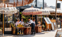 Guests enjoying a sunny terrace with umbrellas