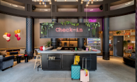 A modern check-in desk with colorful balloons and luggage.