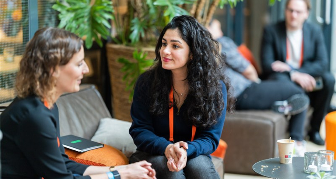 Image of the ONE conference event, two women talking with each other.