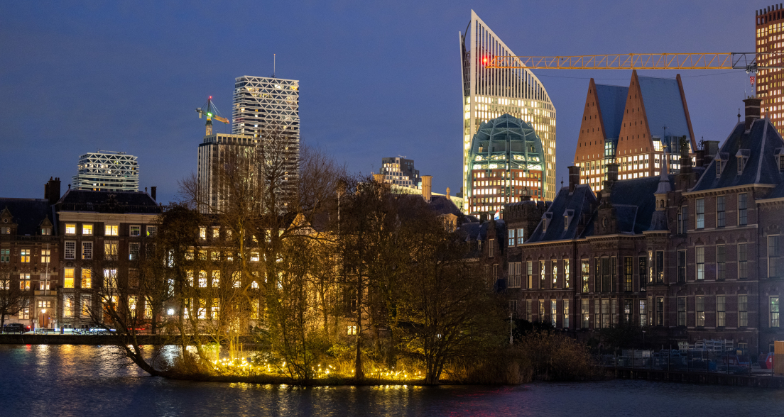 The Hague skyline with illuminated buildings and a harbor.  (c) Arnaud Roelofsz