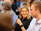 A blonde girl smiling in the crowd