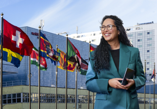 Woman with curly hair wearing a green blazer and smiling