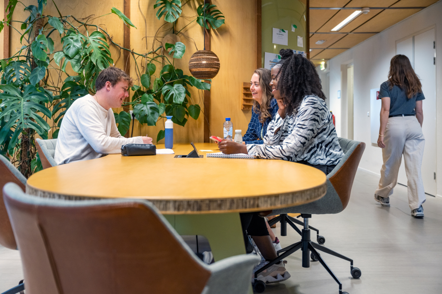 3 colleagues around a table at The Hague Humanity Hub 3 colleagues around a table at The Hague Humanity Hub