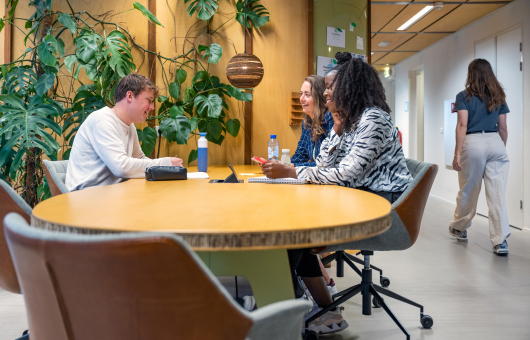 3 colleagues around a table at The Hague Humanity Hub 3 colleagues around a table at The Hague Humanity Hub