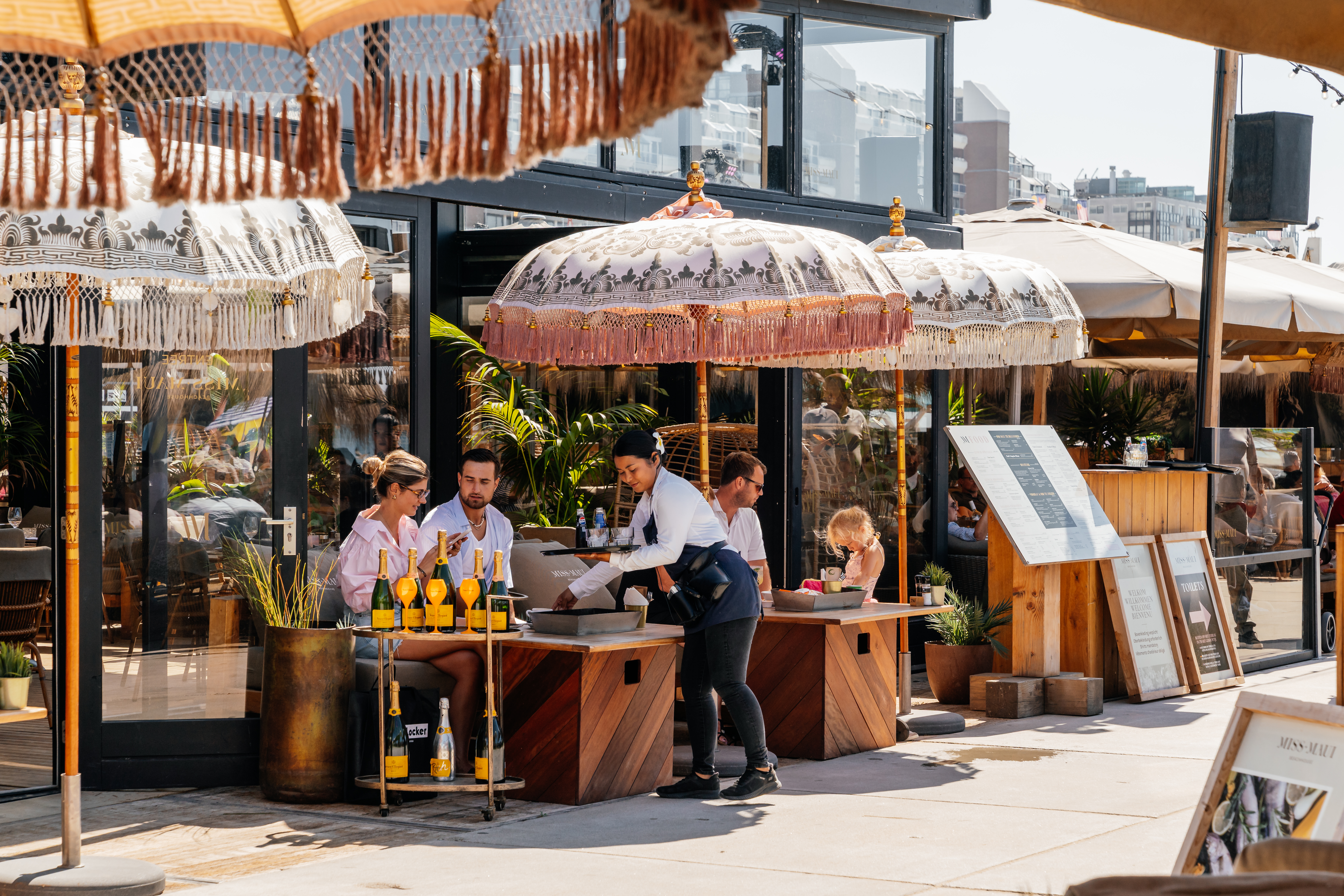 Guests enjoying a sunny terrace with umbrellas