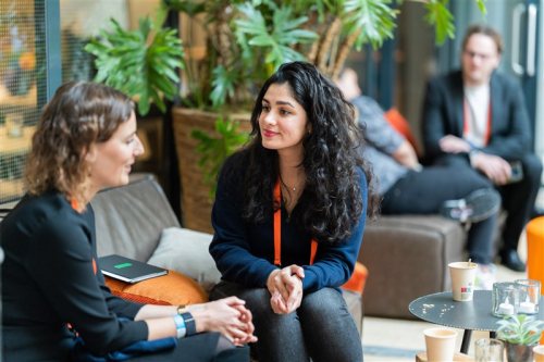 Image of the ONE conference event, two women talking with each other.