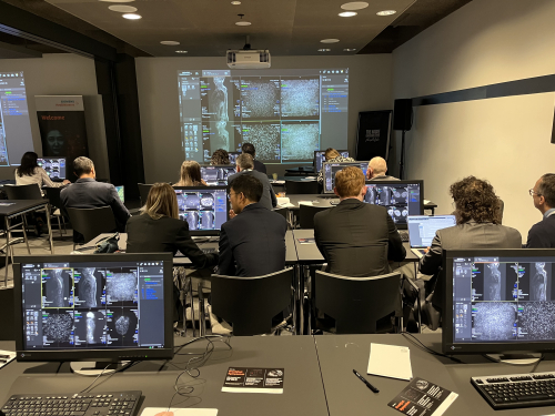 A group of people in a room with computers attending a presentation on medical imaging.