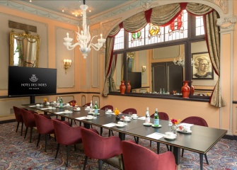 Elegantly decorated meeting room with a long table, chairs, and decorative lighting.