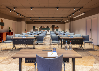 A modern meeting room with tables and chairs.