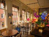 Bright café interior with large windows and colorful flowers