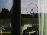 Reflection of a restaurant with a view of a Ferris wheel.