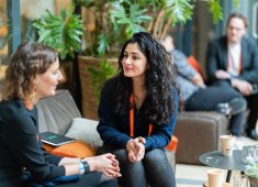Image of the ONE conference event, two women talking with each other.