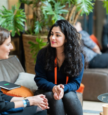Image of the ONE conference event, two women talking with each other.