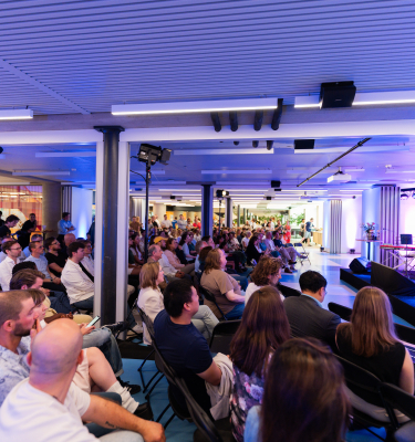 A speaker stands in front of an audience during the Hague Tech Awards.