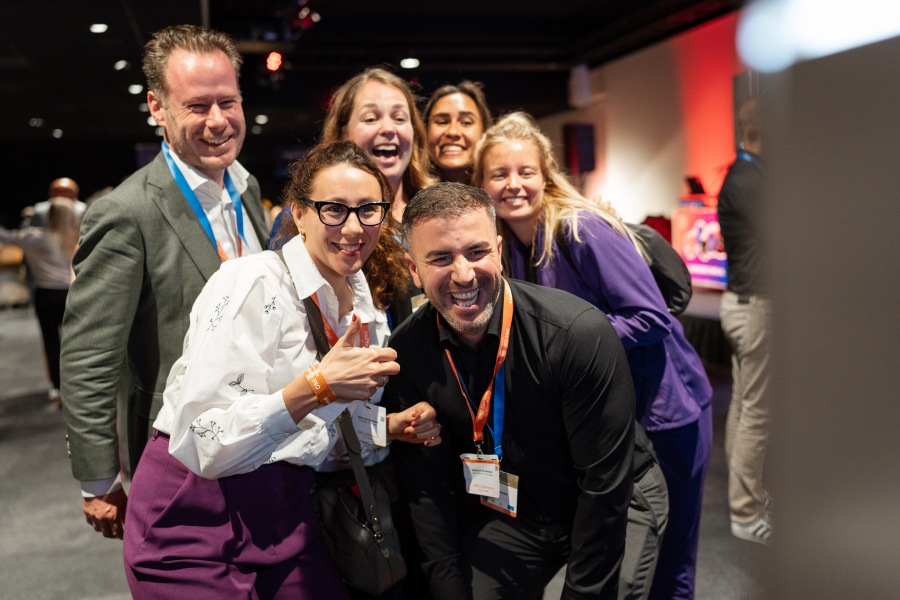 Image of participants smiling at camera at ONE conference business event