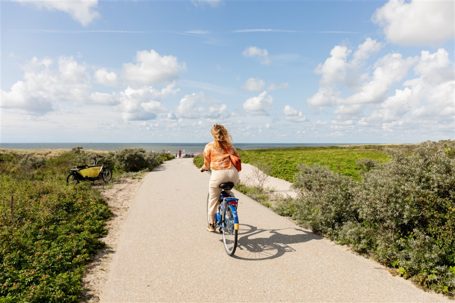 Girl cycling through the dunes of The Hague