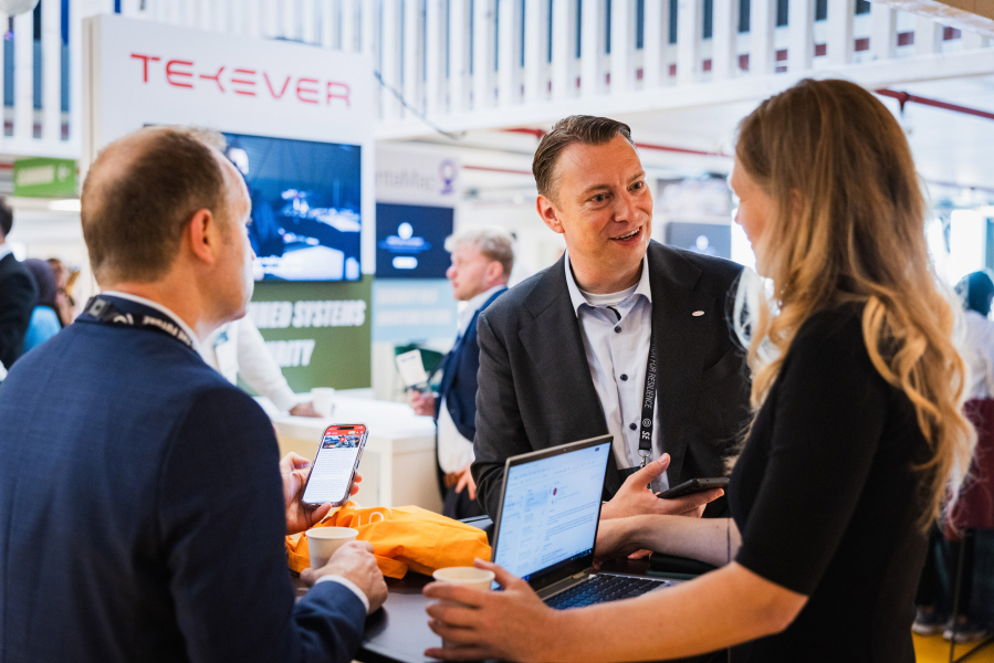 Three people engaged in conversation at a networking event.