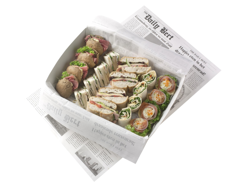 A box filled with assorted sandwiches and wraps on newspaper.
