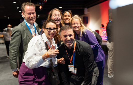 Image of participants smiling at camera at ONE conference business event