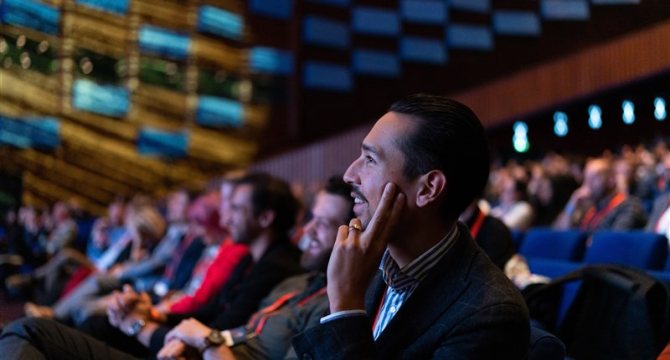 Image of conference participants looking at stage.