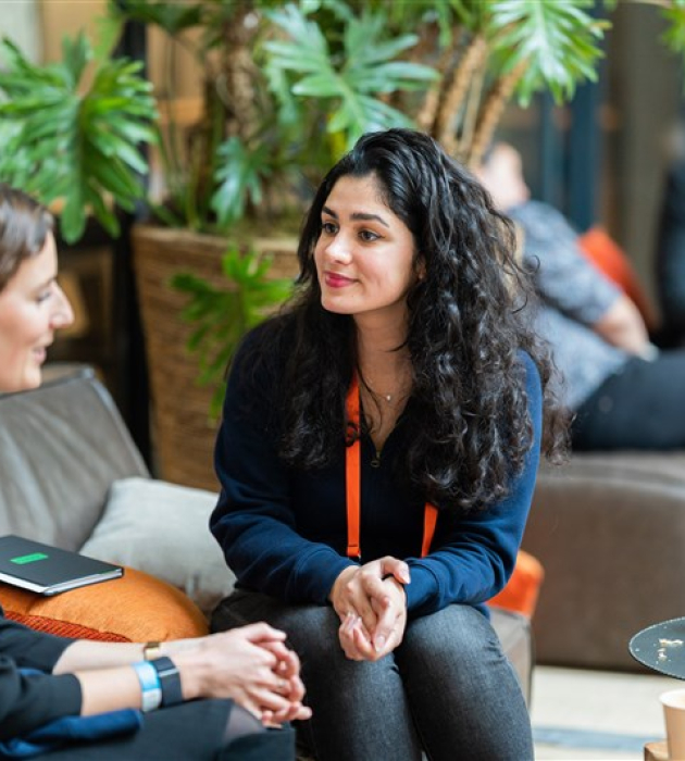 Image of the ONE conference event, two women talking with each other.