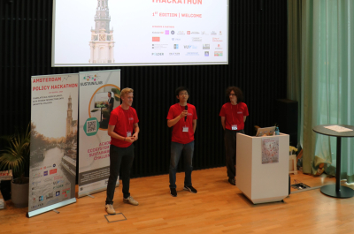 Three speakers in red shirts presenting at a hackathon.
