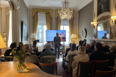 A speaker addressing a group of people in a stylish room.