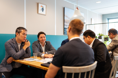 Group of men at a table, engaged in discussion.