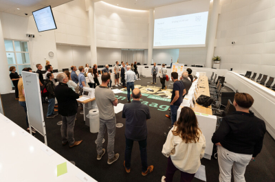 People in a large meeting room in The Hague.