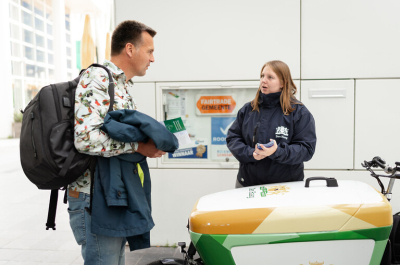 A man in a colorful jacket talks to a woman in a dark blue jacket in The Hague.